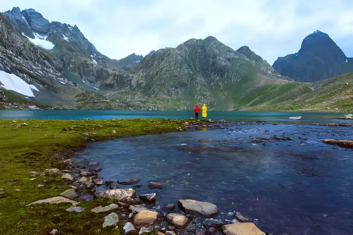 Hikers fishing at vishansar lake on great lakes trek